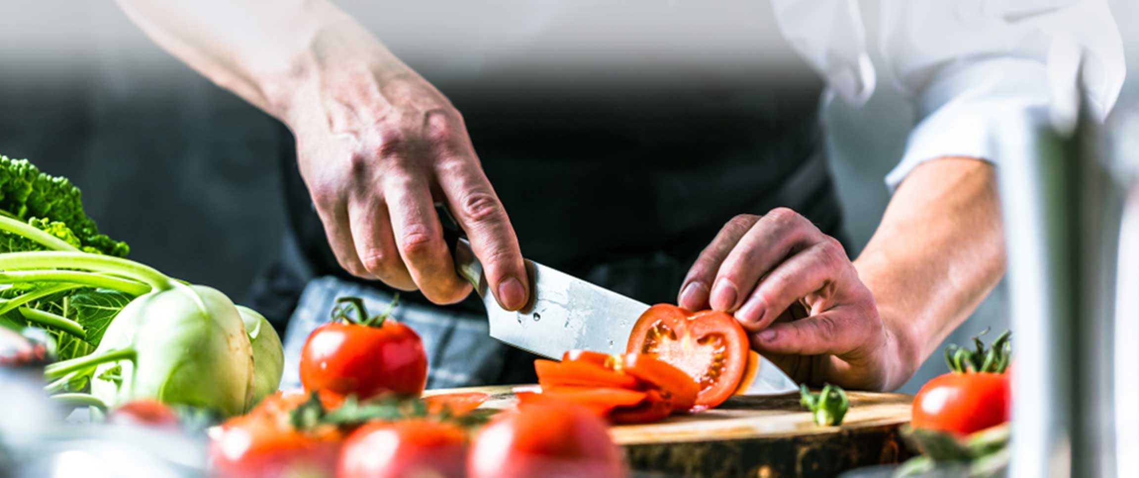 Chef cutting a tomato