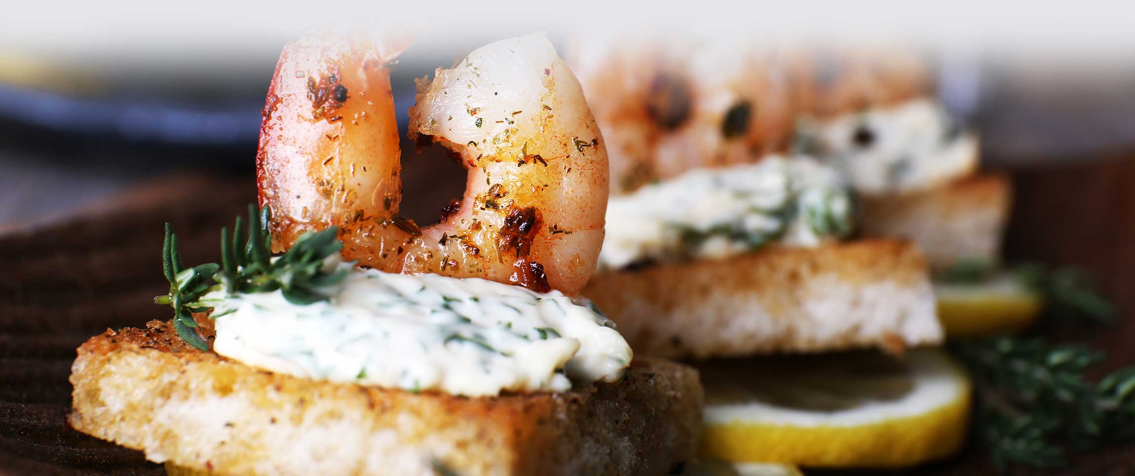 Flame Grilled Shrimp on Toast Point with Dill and Citrus Infused Goat Cheese.