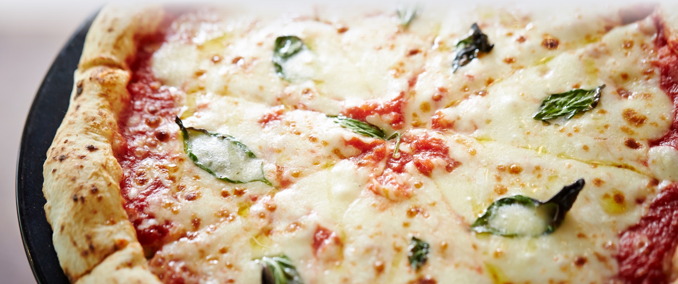 Fresh cheese pizza with basil leaves